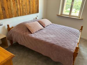 a bedroom with a bed with two pillows on it at La Belle Vue - Gîte 3 étoiles Eco Responsable Climatisé in Maury