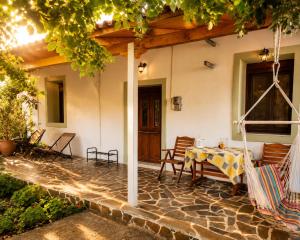 a patio with a table and chairs on a house at Small Villa Gerani in Agios Vlasios