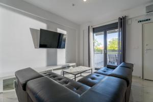 a living room with a couch and a television at SithoniaRS Sea Nomad Luxury Maisonette in Nikiti