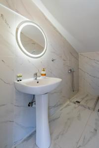 a white bathroom with a sink and a mirror at SithoniaRS Sea Nomad Luxury Maisonette in Nikiti +80 photos