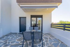 a patio with two chairs and a table at SithoniaRS Sea Nomad Luxury Maisonette in Nikiti