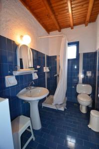 a blue tiled bathroom with a sink and a toilet at Villas Kalafatis Apartments in Kalafatis
