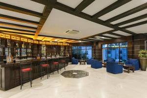 a bar in a hotel with blue chairs and tables at Ramada Khajuraho in Khajurāho