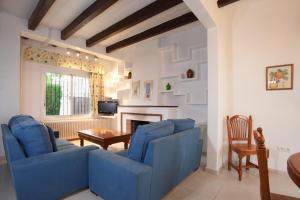 a living room with blue chairs and a fireplace at Sunway Torre La Veleta in Sitges