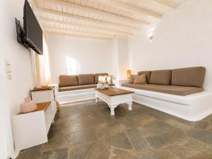 a living room with two couches and a tv at Cozy Summer House in Mikonos