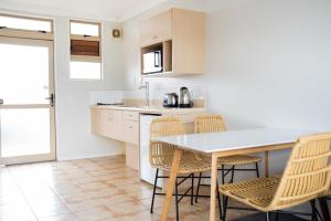 a kitchen with a table and chairs in a room at Raglan Sunset in Raglan