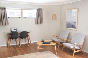 a living room with chairs and a table at Raglan Sunset in Raglan