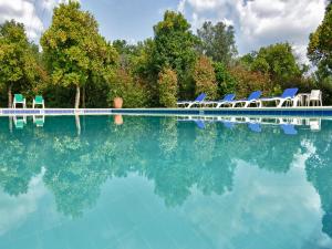 a swimming pool with blue chairs and the water at Solar da Salvadoura in Amares