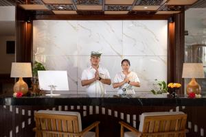 two people standing in front of a screen with their hands praying at The Prime Seminyak by Kanaya Hospitality in Seminyak +62 photos