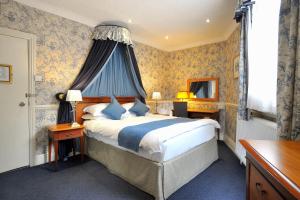 a bedroom with a bed with a blue canopy at Royal Hotel in Bath