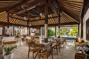 a dining area with tables and chairs in a pavilion at The Prime Seminyak by Kanaya Hospitality in Seminyak