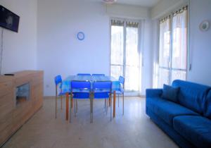 ボルゲット・サント・スピーリトにあるAppartamento Stella Marisのリビングルーム(テーブル、青い椅子、ソファ付)
