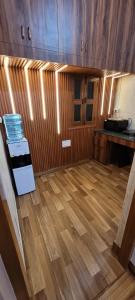 a room with a kitchen with wooden floors and cabinets at Casa Aura in Lucknow