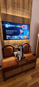 a couch with a tv in a living room at Casa Aura in Lucknow