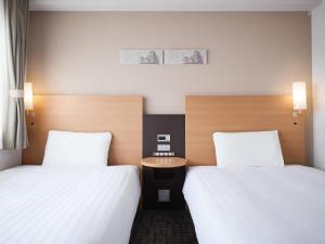 two beds in a hotel room with white sheets at Comfort Hotel Himeji in Himeji +28 photos