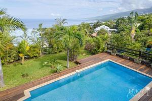 a swimming pool on a deck with a view of the ocean at Villa Stella in Saint-Leu