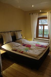 a large bed in a bedroom with a window at Ferienhaus Altes Schifferhaus in Oedelsheim
