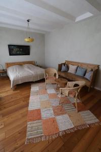 a bedroom with a bed and a couch and a rug at Ferienhaus Altes Schifferhaus in Oedelsheim