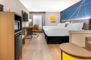 a hotel room with a large bed and a table at Comfort Inn & Suites Saint Louis Lafayette Square in Saint Louis +30 photos