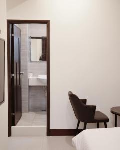 a bedroom with a mirror and a chair and a sink at 十二籃民宿 in Magong