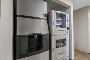a stainless steel refrigerator next to a drink dispenser at Quality Inn Neosho in Neosho