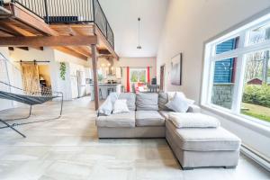 a living room with a couch and a chair at Spa Relaxation & Adventure - Lapointe du Lac in Saint-Gérard