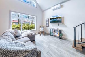 a living room with a couch and a tv at Spa Relaxation & Adventure - Lapointe du Lac in Saint-Gérard