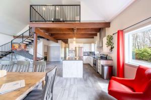 a kitchen and dining room with a red chair at Spa Relaxation & Adventure - Lapointe du Lac in Saint-Gérard