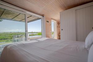 a bedroom with a large bed and a large window at Mas des Cabidoules in Saintes-Maries-de-la-Mer +33 photos