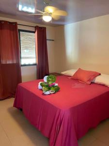a bedroom with a pink bed with a pink table at Fare Te Vaite in Tikehau Airport +4 photos