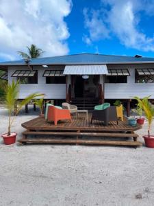 a house on the beach with colorful chairs on a deck at Fare Te Vaite in Tikehau Airport