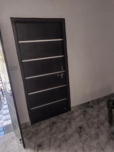 a black door in a room with marble floors at Bari Mata home ste in Lakāwās