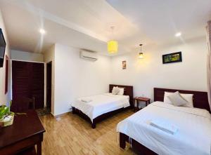 a hotel room with two beds and a television at Monterey Angkor Boutique in Phum Pobos