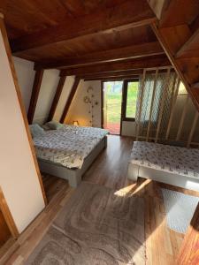 a bedroom with two beds and a large window at Przystań Kownatki in Kozłowo