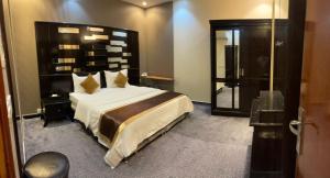 a bedroom with a large bed and a walk in shower at ABHASKY Serviced Apartmentsشقق مخدومة اقتصادي in Abha