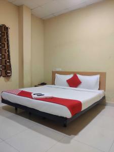 a bedroom with a large bed with red and white pillows at Hotel O CANARIES RETIREES RESIDENCY in Kottakupam