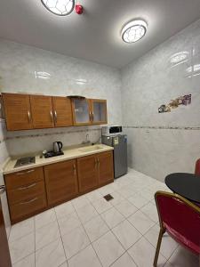 a kitchen with wooden cabinets and a refrigerator at ABHASKY Serviced Apartmentsشقق مخدومة اقتصادي in Abha