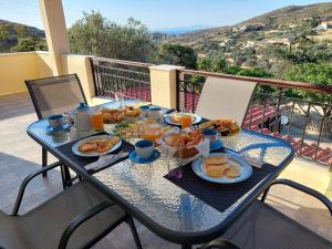 a table with breakfast food on a balcony at MAFILVI Panorama in Chrousa
