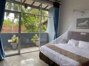 a bedroom with a bed and a large window at Sun and Waves Beach Cottage Ahungalla in Ahungalla +18 photos