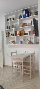 a table and a chair in a room with books at Enki's Garden in Tirana