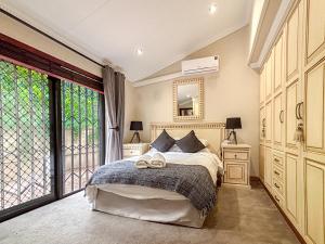 a bedroom with a bed and a large window at BondMakers Hidden Gem in Hartbeespoort +26 photos