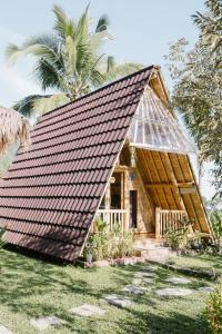 a wooden house with a thatched roof at Bali Hidden Lemukih in Sawan
