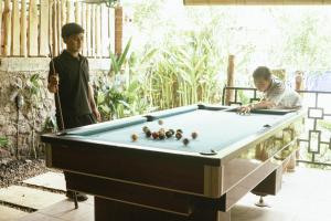 two men playing a game of pool in a yard at Bali Hidden Lemukih in Sawan