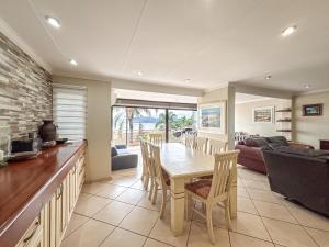 a dining room and living room with a table and chairs at BondMakers Hidden Gem in Hartbeespoort