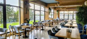 a restaurant with tables and chairs and windows at Solid Magic Apart Hotel in Mamaia