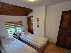 a bedroom with two beds and a window and a door at Вила Беевски in Gela +34 photos