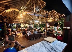 a group of people sitting in a restaurant at Secret Garden Surf Resort, walk to waves in Pulau Gilkaliantan