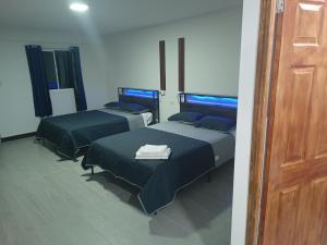 a room with three beds and a wooden door at Suits hotel boutique in Nuevo Casas Grandes +17 photos