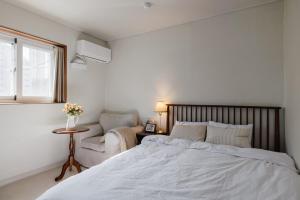 a bedroom with a bed and a chair and a window at 포켓서울 문래점 in Seoul