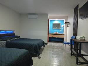 a hotel room with two beds and a television at Suits hotel boutique in Nuevo Casas Grandes